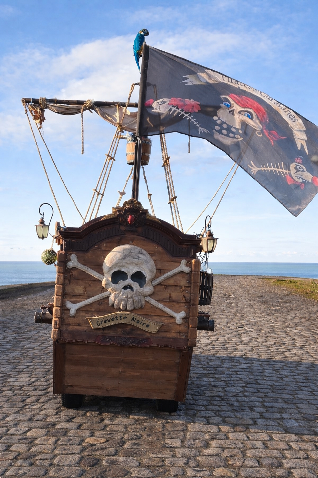 Le Crevette Noire vu de l’arrière sur des pavés, avec sa tête de mort et son pavillon pirate